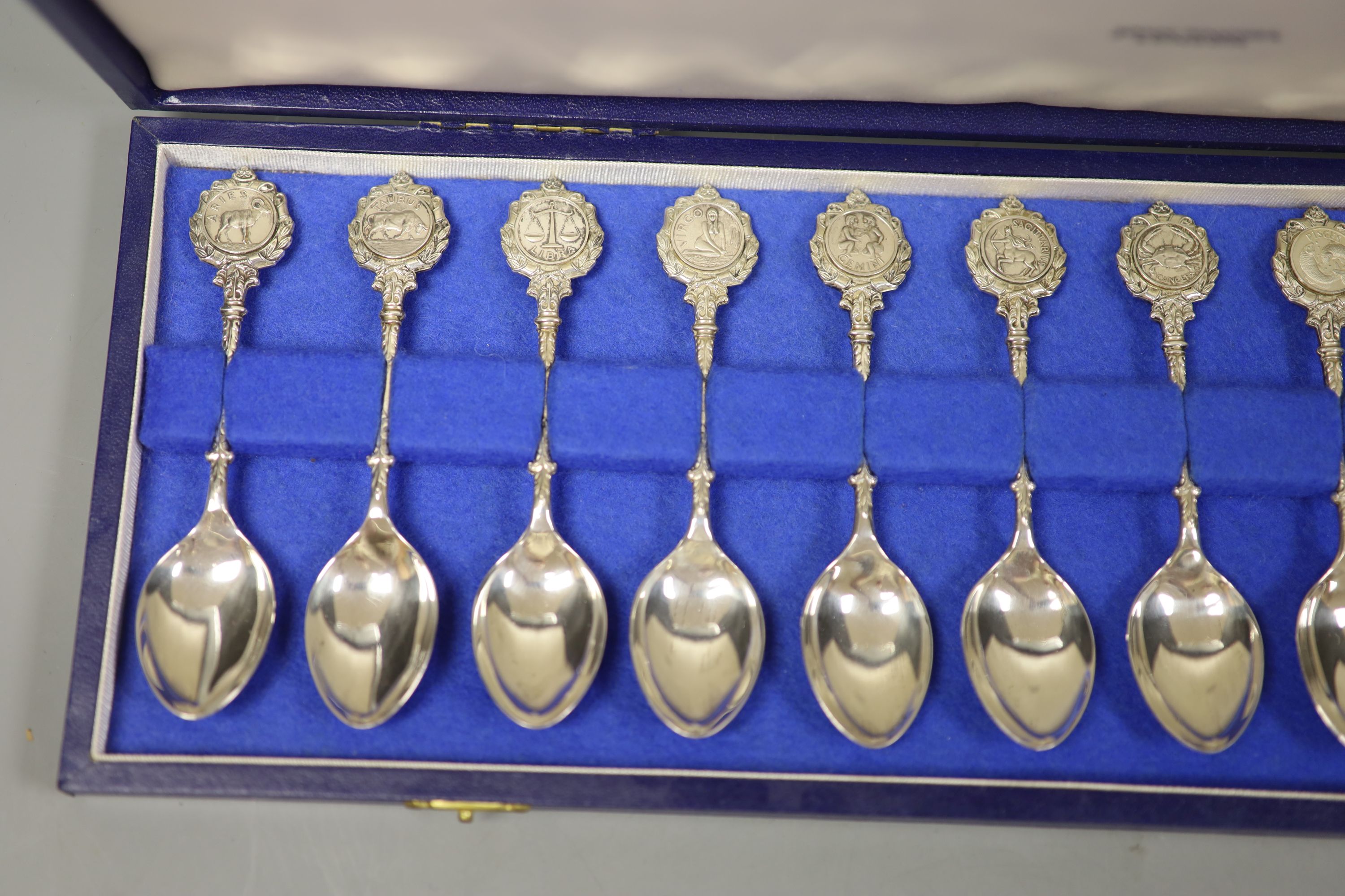 A set of twelve silver Signs of the Zodiac spoons by John Pinches, cased
